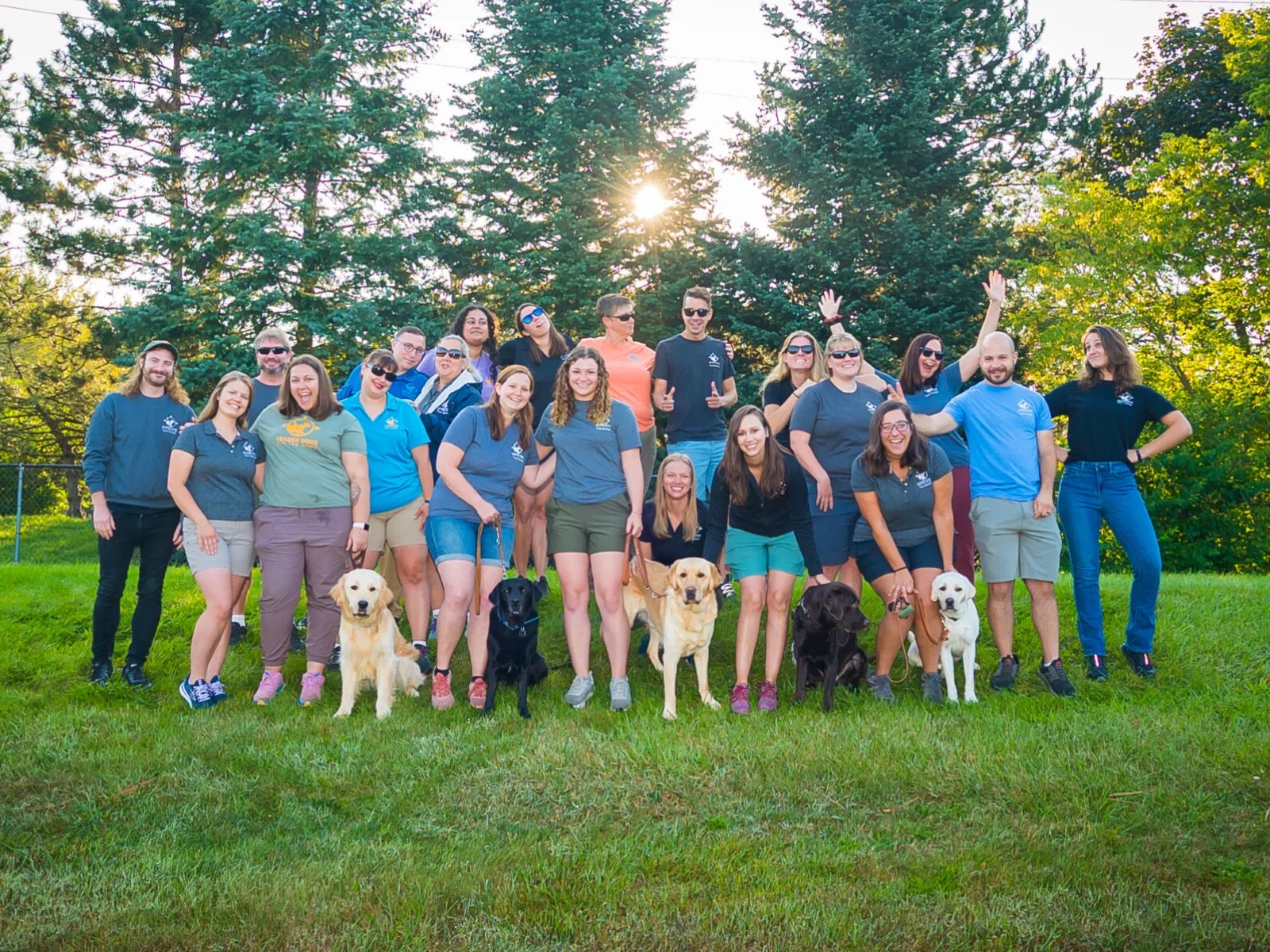 Leader Dogs for the Blind staff and trainers posing outdoors with their guide dogs