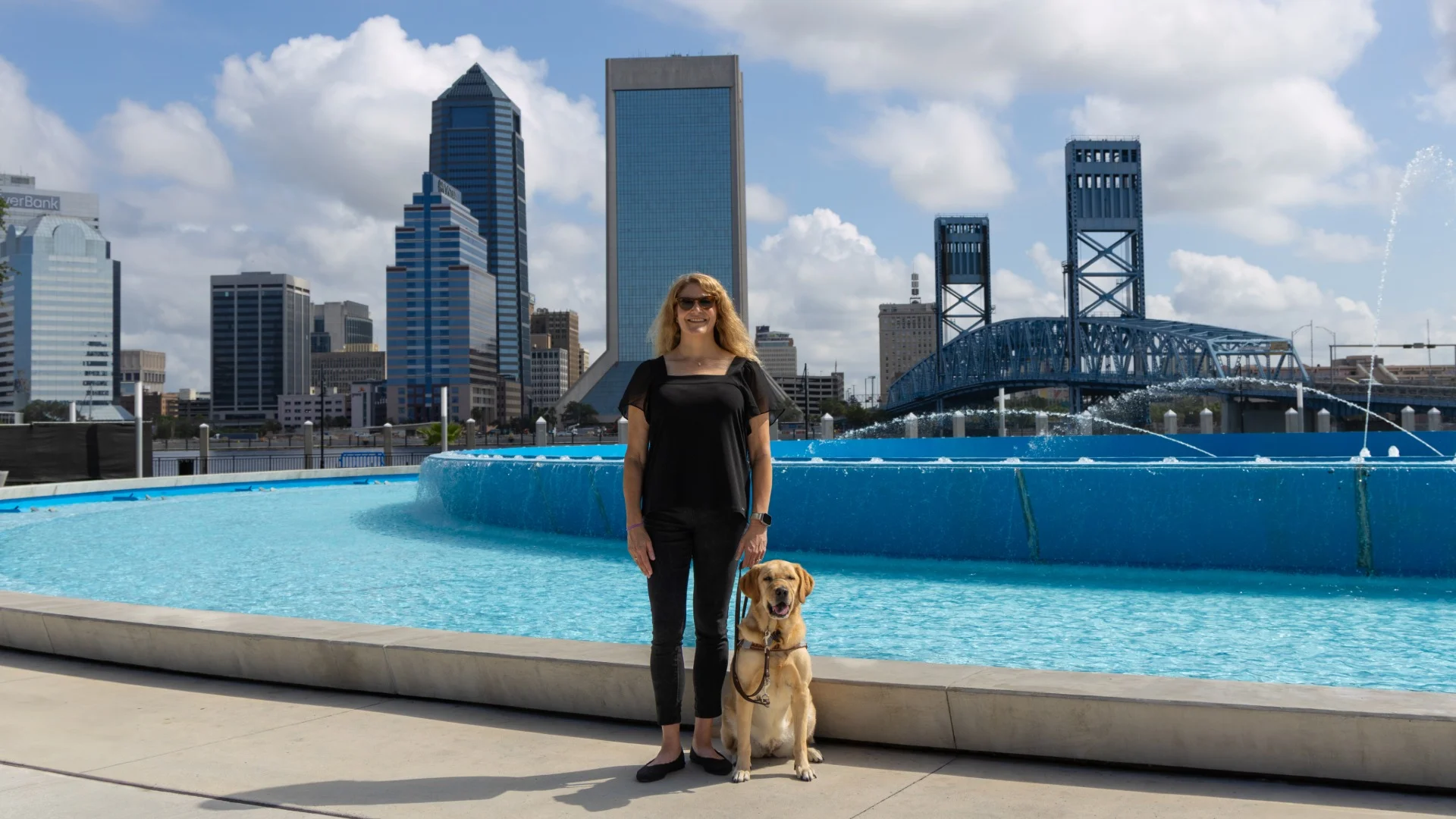 A guide dog user navigating with their trained guide dog — a symbol of the independence Eye Spy Foundation works to support