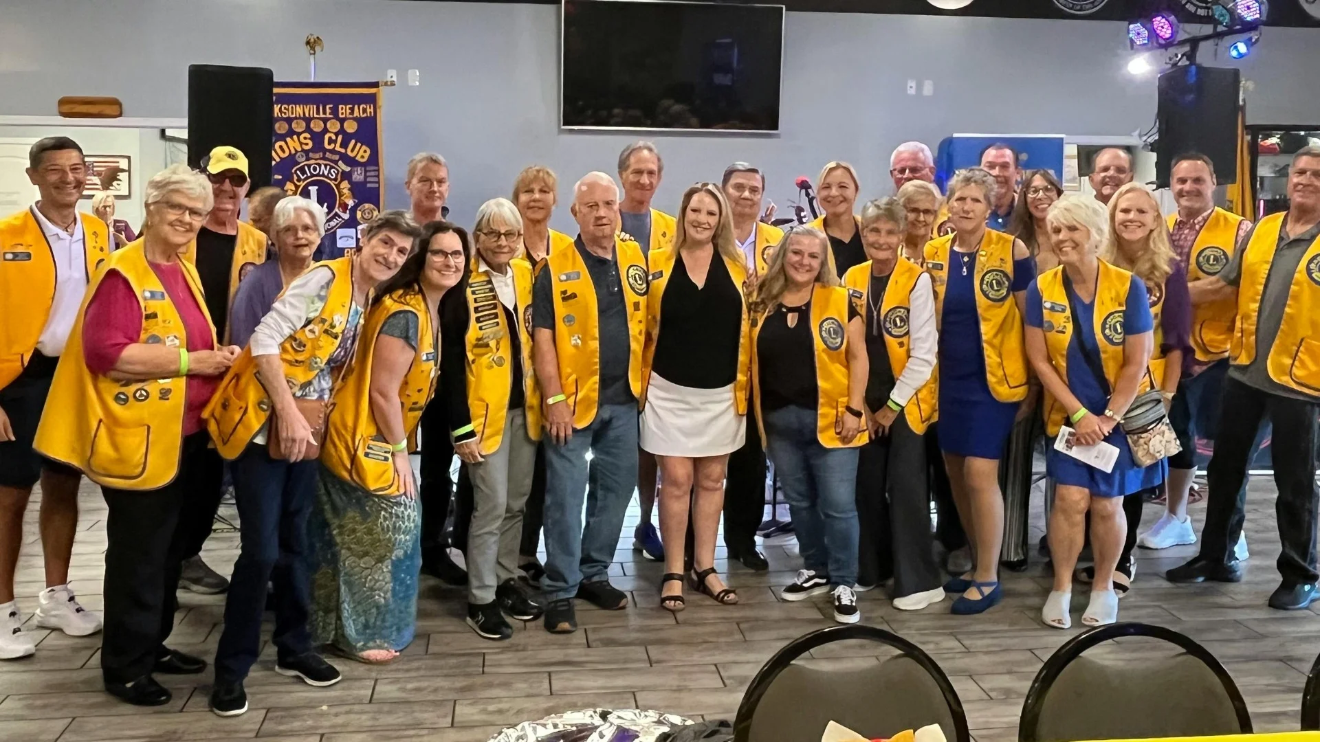 Lions Club Jacksonville Beach members at a Barktoberfest community event, celebrating with the club banner